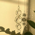 Crystal hanging ornament with sunlight filtering through on a neutral background
